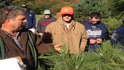 The instructor, Steve Kristoph, shows his students a branch from a conifer.
