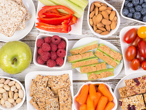 Photo: Celery with peanut butter, apple, tomatoes, carrots, almonds, raspberries, and other healthy snacks.