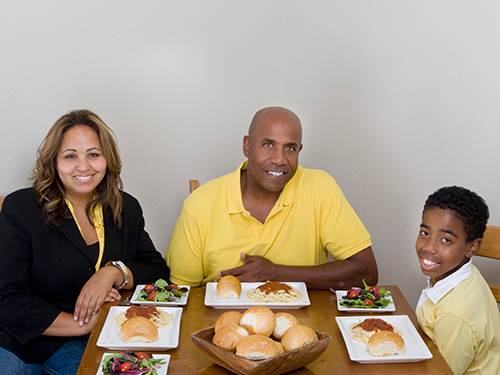 Photo: Family sitting around dinner table.