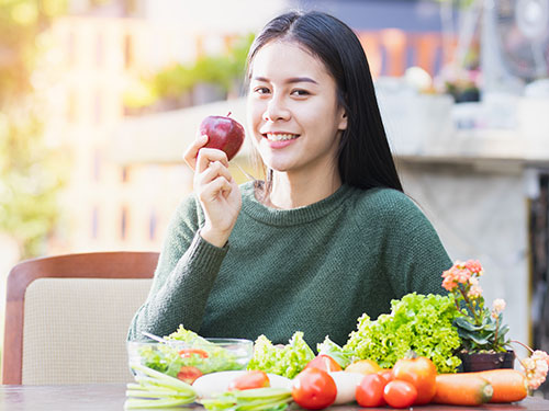 Photo: A teenage girl holding an apple.
