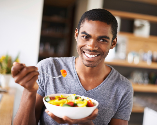Photo: Man eating salad.