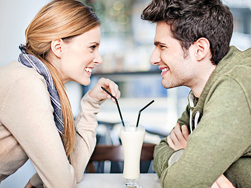 Photo: couple sharing a milkshake.