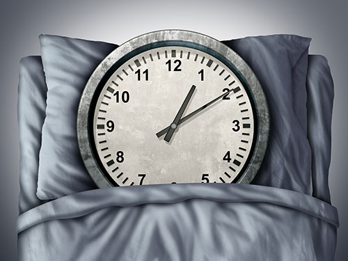 A wall clock placed in a bed.