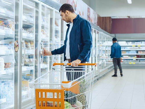 Photo: Young man pushes shopping cart.