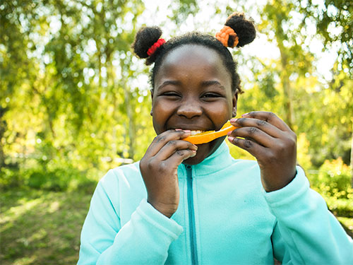 Photo: Child eating an orange.