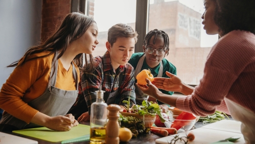 Nutrition educator showing students a yellow pepper.