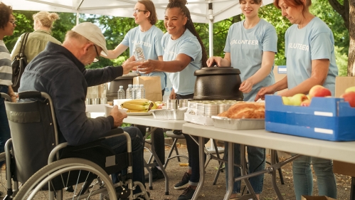 Man in wheelchair at outdoor food pantry.