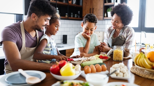 Family preparing healthy food in kitchen together.