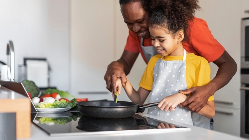 Father and daughter cooking healthy meal.