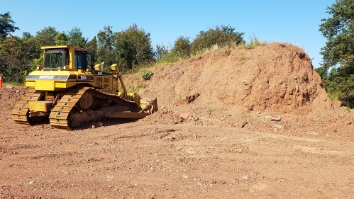 Bulldozer excavating stockpiled soil.