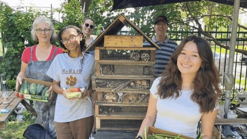 Several people holding produce.