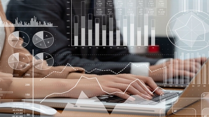 Different graphs and charts overlaid on a person typing on their laptop.