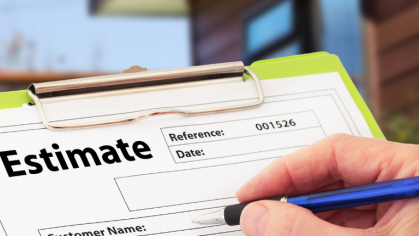 A hand holding a blue pen is about to write on a paper for some kind of estimate that is on a neon green clipboard.