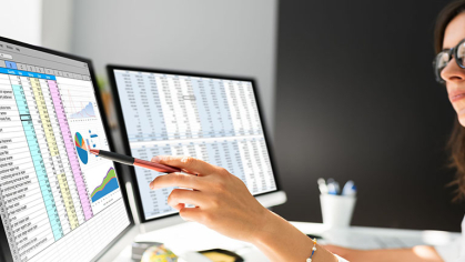 A person examines a graph on an excel spreadsheet for accuracy. She is deeply focused on her task.
