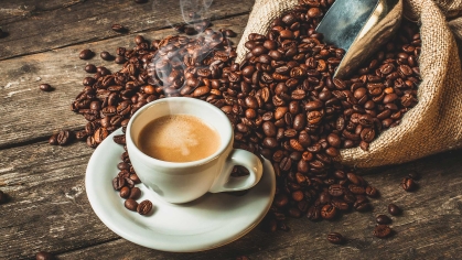 Coffee in a cup by a sack of coffee beans