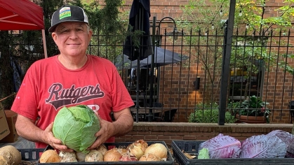 A person holding a head of cabbage.
