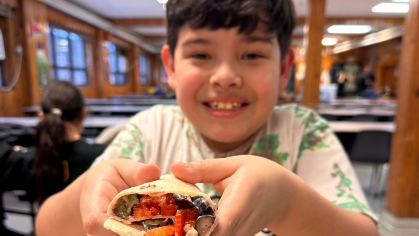 A child with a wrap-style sandwich.