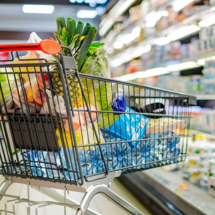 Shopping cart in grocery store aisle.