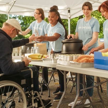 Man in wheelchair at outdoor food pantry.
